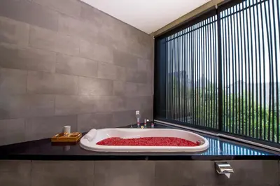 a bathroom with a bath tub with a large window at Villa DeDayuh Seminyak in Seminyak