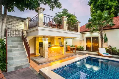 a villa with a swimming pool and a house at KELAN-TEL BALI in Jimbaran