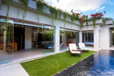 a villa with a swimming pool and a house at Kedonganan Beach Villas in Jimbaran