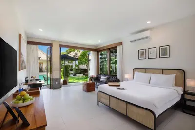 a bedroom with a large bed and a living room at Huge 11 BR Villa, Sleeps 41, Prime Area, Near Beach in Canggu