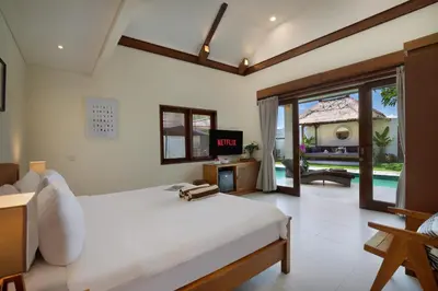 a bedroom with a white bed and a large window at Huge 11 BR Villa, Sleeps 41, Prime Area, Near Beach in Canggu