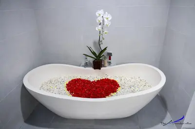 a white bath tub with a heart made out of flowers at The Awandari Villas Seminyak in Seminyak