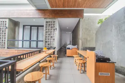a restaurant with wooden tables and stools at D Home Seminyak in Seminyak