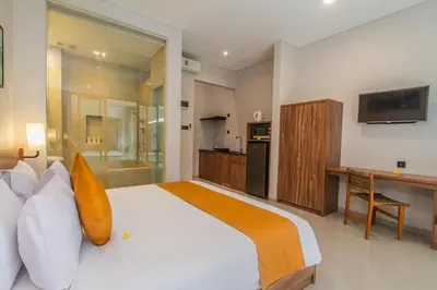 a bedroom with a large bed and a bathroom at D Home Seminyak in Seminyak