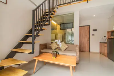 a living room with a staircase and a table at D Home Seminyak in Seminyak