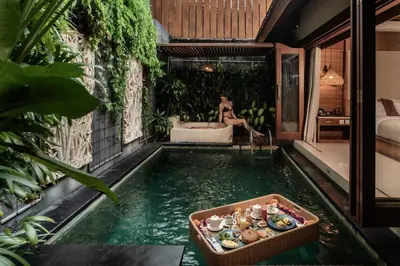a pool in the middle of a house with a woman sitting in a tub at Seminyak Sanctuary Villa by Ini Vie Hospitality in Seminyak