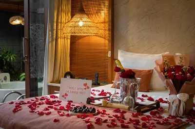 a table with red rose petals on a bed at Seminyak Sanctuary Villa by Ini Vie Hospitality in Seminyak