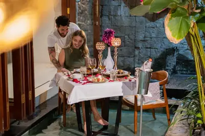 a man and a woman sitting at a table with food at Seminyak Sanctuary Villa by Ini Vie Hospitality in Seminyak