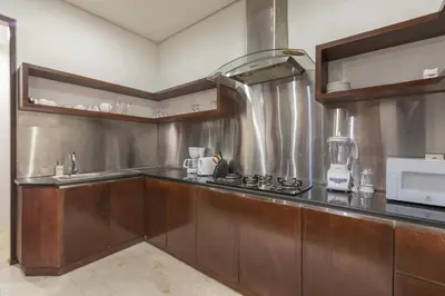 a kitchen with wooden cabinets and a counter top at Villa Litera Seminyak Bali in Seminyak