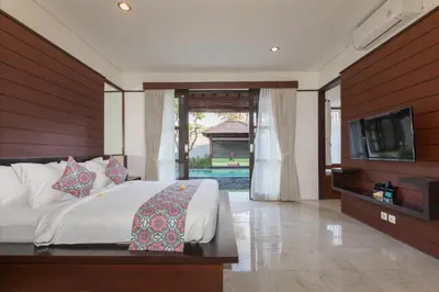 a bedroom with a bed and a flat screen tv at Villa Litera Seminyak Bali in Seminyak