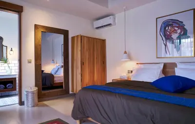 a bedroom with a large bed and a mirror at Villa Brabhan Seminyak in Seminyak