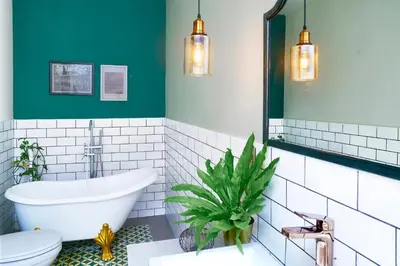 a bathroom with a tub and a green wall at Villa Brabhan Seminyak in Seminyak