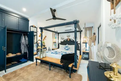 a bedroom with a blue canopy bed and a table at Luxe 5 Bed, Sleeps 10, Butler, Walk to ShopsCafe in Seminyak