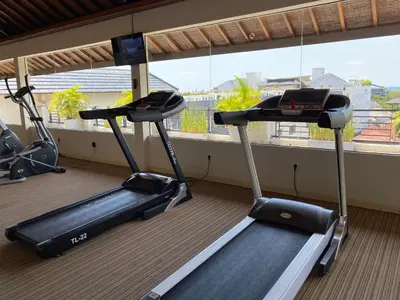 two exercise bikes in a room with a window at Stylish 2 Bedroom Penthouse Apt, Newly Refreshed, 50 Mbps, Pool, Gym, Resto in Kuta