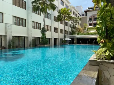 a large swimming pool in front of a building at Stylish 2 Bedroom Penthouse Apt, Newly Refreshed, 50 Mbps, Pool, Gym, Resto in Kuta