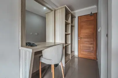 a home office with a wooden desk and a chair at D Sarian Seminyak in Seminyak