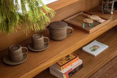 a table with two cups and books on it at Desa Potato Head Bali in Seminyak
