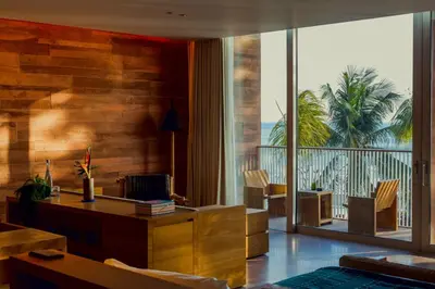 a living room with a desk and a balcony at Desa Potato Head Bali in Seminyak