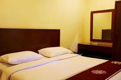 a bed in a room with a mirror and a bed sidx sidx sidx at Niramaya Villa in Seminyak