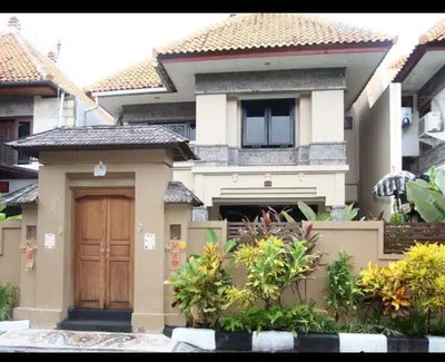a house with a wooden door in front of it at Villa Indah Kuta Royal - Private Pool - Optic Fiber High Speed Internet in Kuta