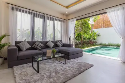 a living room with a couch and a swimming pool at Villa Azura in Seminyak
