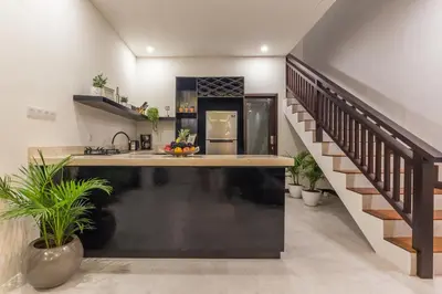 a kitchen with a counter top and a staircase at Villa Azura in Seminyak
