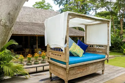 a bed on the deck of a resort at Chanteak Bali in Jimbaran