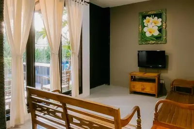a living room with a bench and a television at The Lavana Arimanu Kuta in Kuta