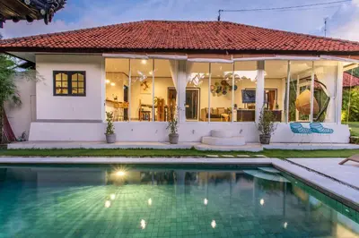 a house with a swimming pool in front of it at Villa Janitra in Seminyak