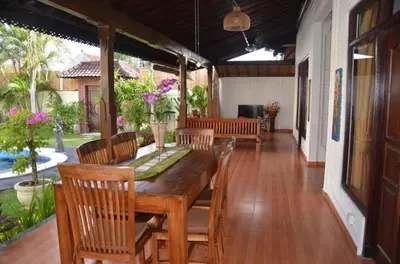 a dining room with a wooden table and chairs at Tegal Uma Seminyak by Maha Bali in Seminyak
