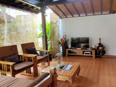 a living room with a couch and a television at Tegal Uma Seminyak by Maha Bali in Seminyak