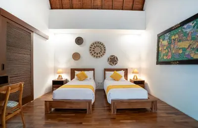 two beds in a room with a tv at Kusuma Living and Villa Seminyak in Seminyak