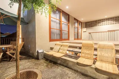 a patio with chairs and a table and a tree at The jero 18 kuta guest house in Kuta