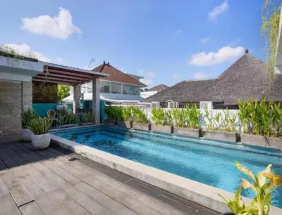 a swimming pool in front of a house at Lolo #2 Apartment by Betterplace in Canggu