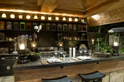 a restaurant with a bar with wine glasses at Villa Jasli in Canggu