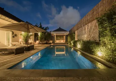 a swimming pool in a backyard with an umbrella at Villa Bloom 5 close to the beach private pool 3 bedrooms 3 bathrooms in Seminyak