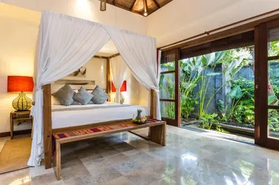 a bedroom with a bed with a canopy at Mango Tree Villas Jimbaran Bali in Jimbaran