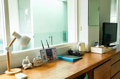 a desk with a television and a lamp and a window at AQ-VA Hotel & Villas Seminyak in Legian