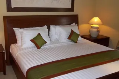 a bedroom with a large bed with two pillows at Apel Villa Sanur in Sanur