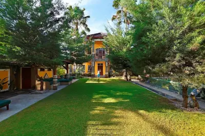 a large yard with trees and a house at Apel Villa Sanur in Sanur