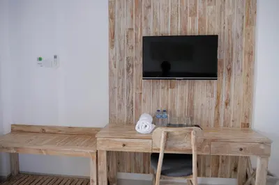 a wooden desk with a television on a wall at Tirtha Khayangan in Canggu