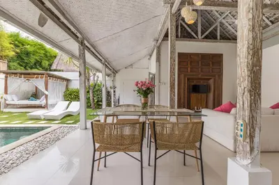 a patio with a table and chairs and a pool at Villa Alegria in Seminyak