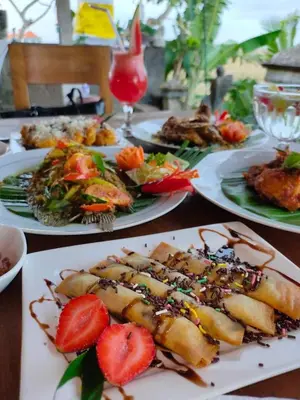 a table topped with plates of food with strawberries at Bali Eco Living Yoga Healing Meditation and Retreat Center in Denpasar