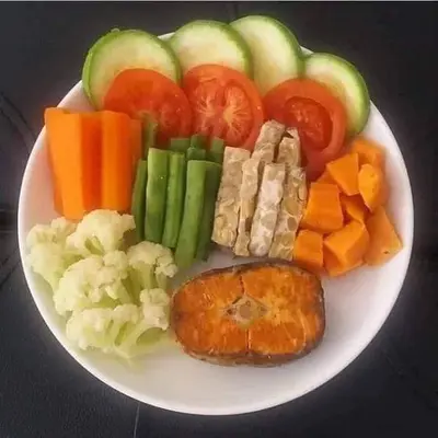 a white plate of food with vegetables and meat at Bali Eco Living Yoga Healing Meditation and Retreat Center in Denpasar