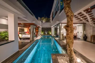 an indoor pool in a house with a tree at Villa Tykhe - Modern Balinese 4BR Pool Villa in Central Seminyak in Seminyak