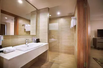 a bathroom with a sink and a shower at Harper Kuta Hotel by ASTON in Legian