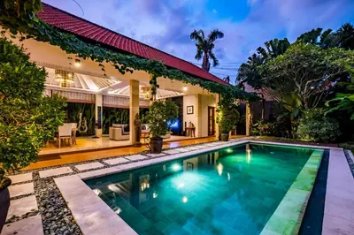 an image of a swimming pool in front of a house at Central Seminyak Villa Martini in Seminyak