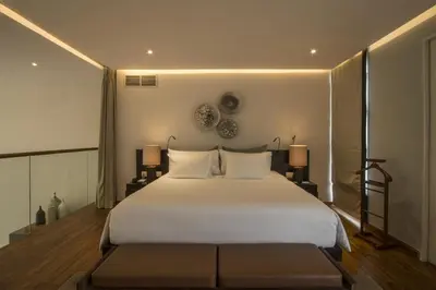 a bedroom with a large white bed and two lamps at hu'u Villas in Seminyak