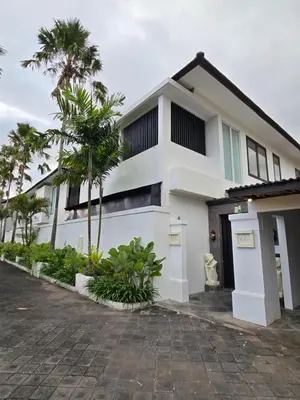a white house with palm trees in front of it at Villa Akasha Luxury 6 bedroom villa near beach in Canggu