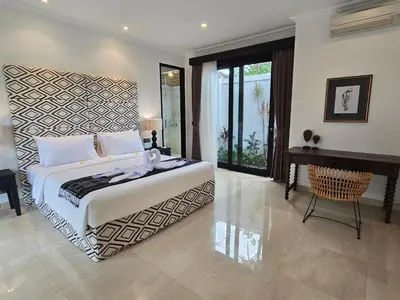 a bedroom with a large bed and a piano at Villa Akasha Luxury 6 bedroom villa near beach in Canggu